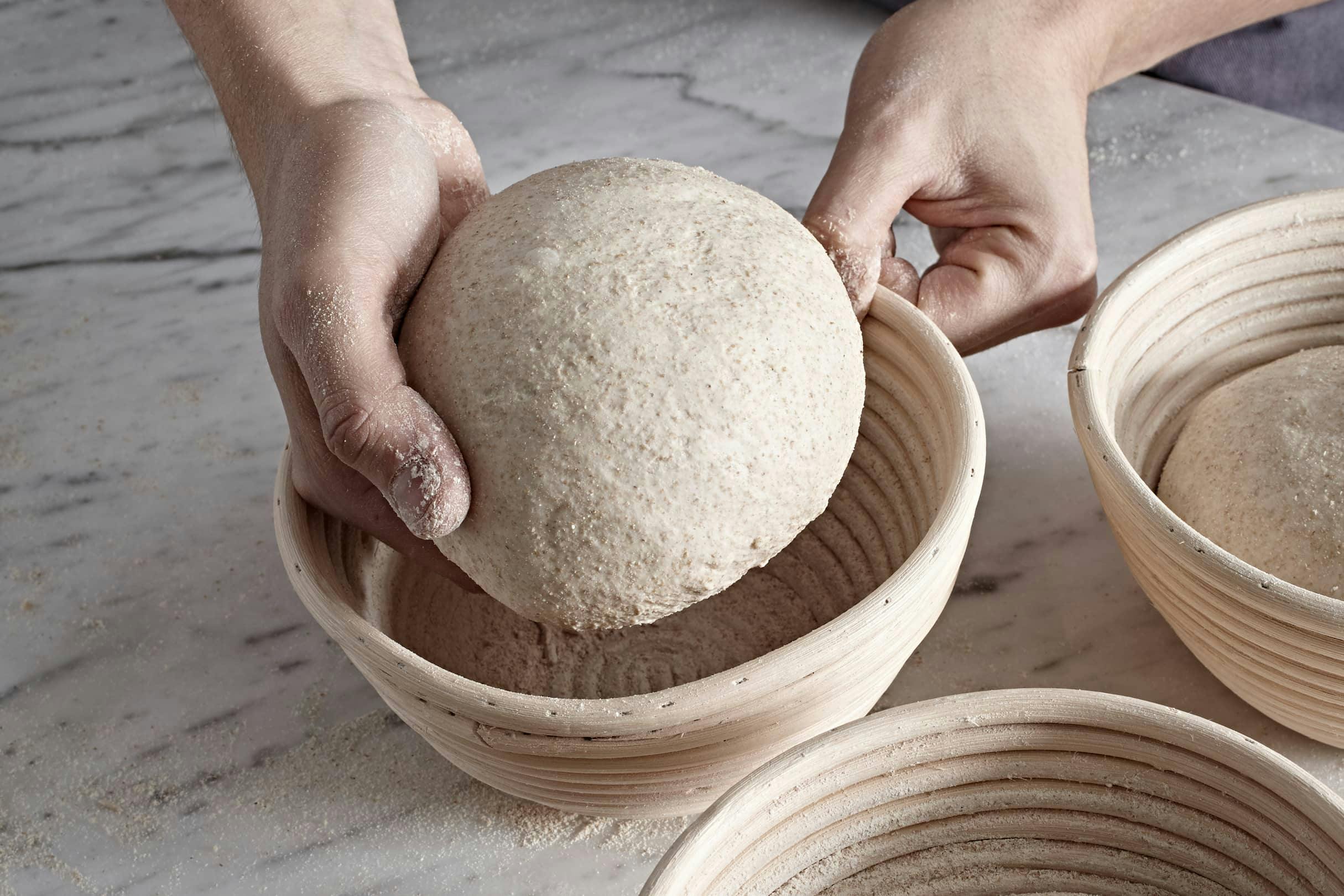 Die per Hand geformten Sauerteiglaibe werden in Backformen gelegt