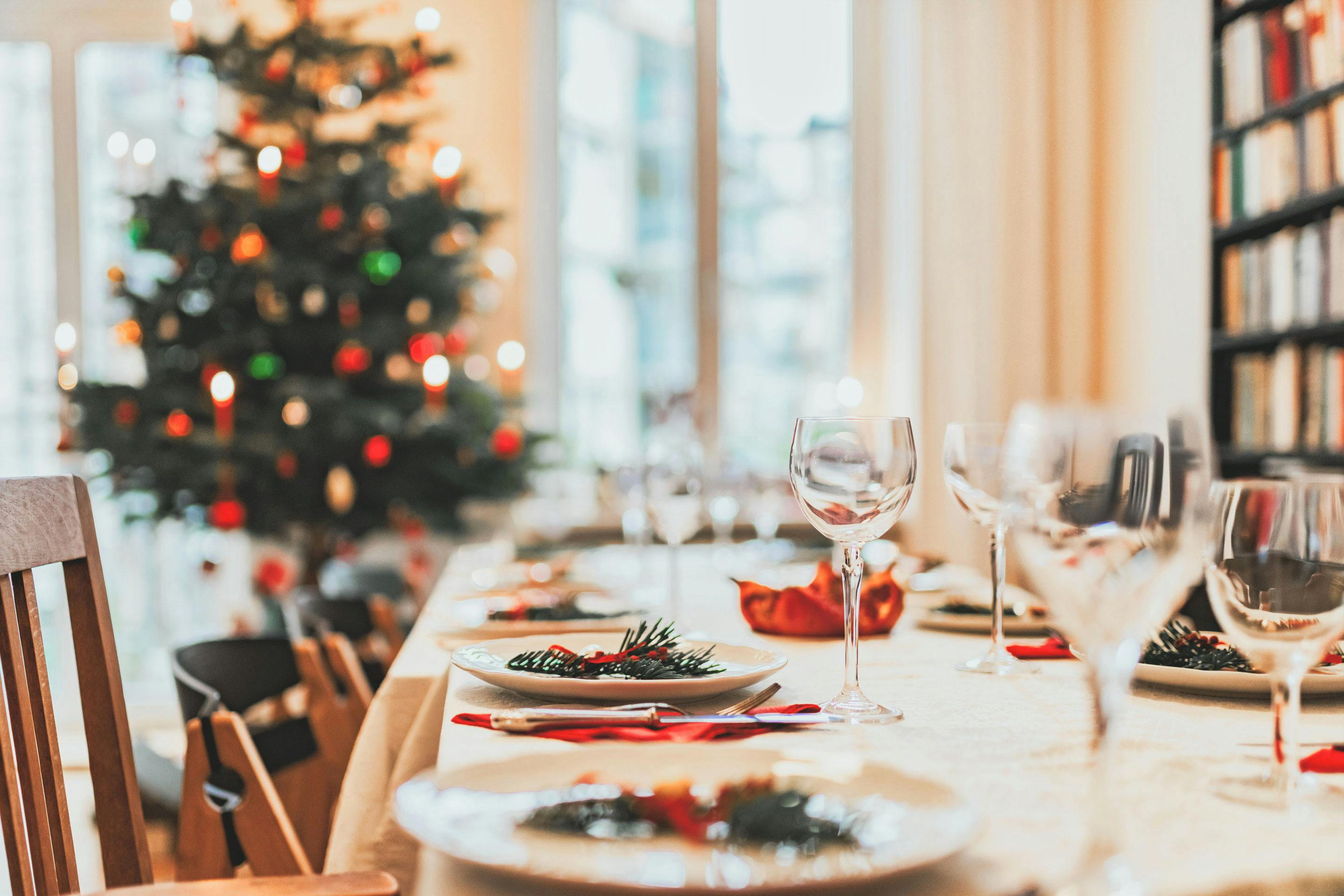 festlich gedeckter Weihanchsttisch mit Christbaum im Hintergrund