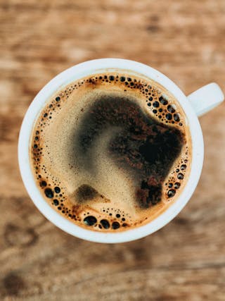 eine Tasse mit Kaffee von oben fotografiert