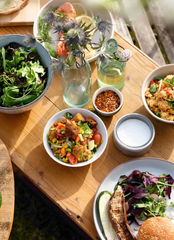 Verschiedene Salate angerichtet auf einem Tisch im Freien